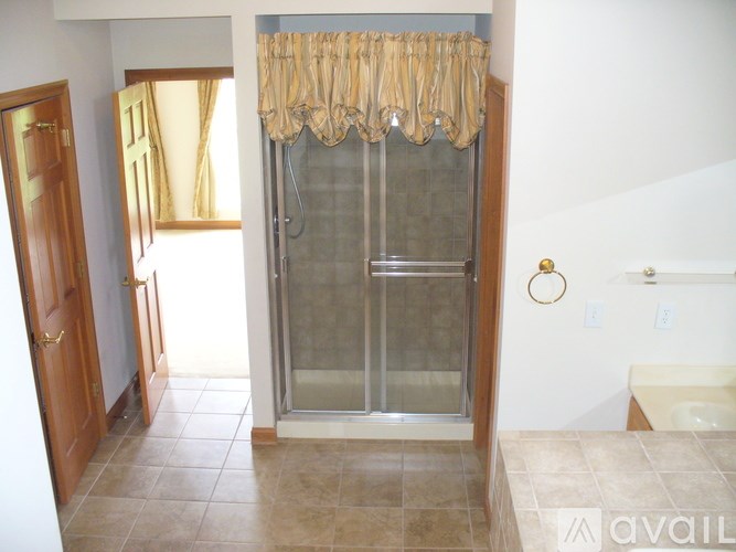 A bathroom with a glass shower door and a towel rack.