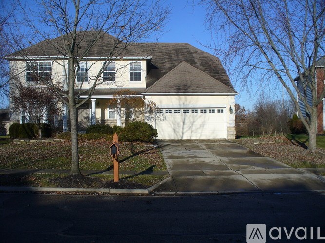 A house with a driveway and a mailbox in front.