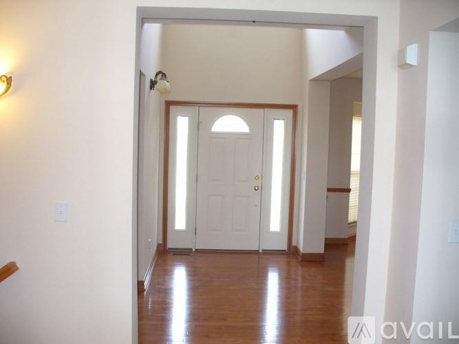 A hallway with a white door and a light on the wall.