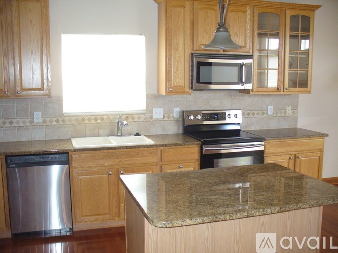 A kitchen with wooden cabinets and granite countertops.