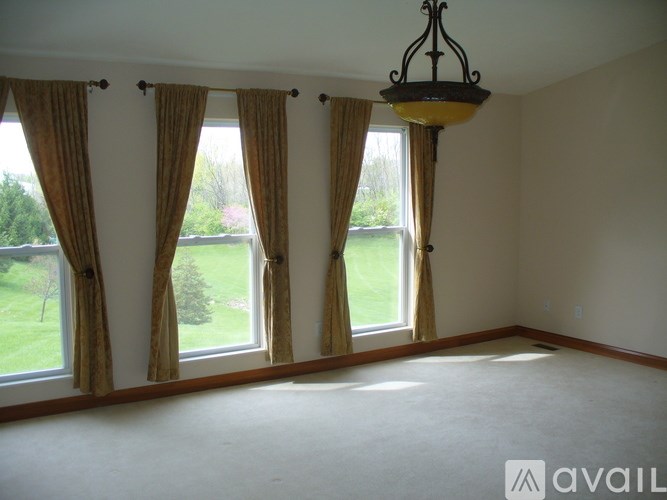 A room with a large window and a hanging light fixture.