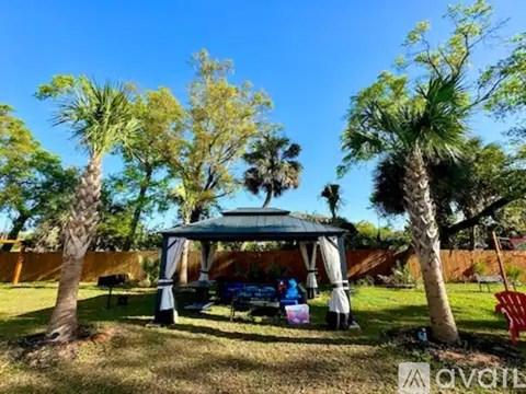 A family is sitting under a gazebo in a park.