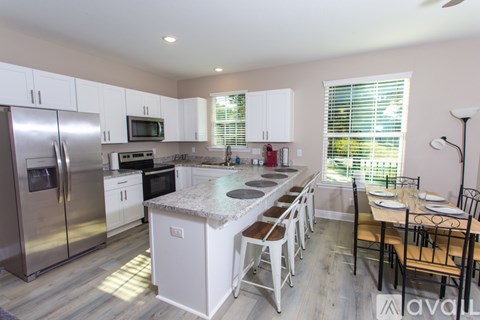 A kitchen with white cabinets and a granite countertop.