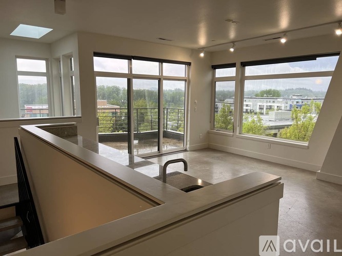 A spacious office with large windows overlooking a green landscape.