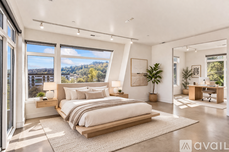 A bedroom with a large bed and a view of the outdoors through the windows.