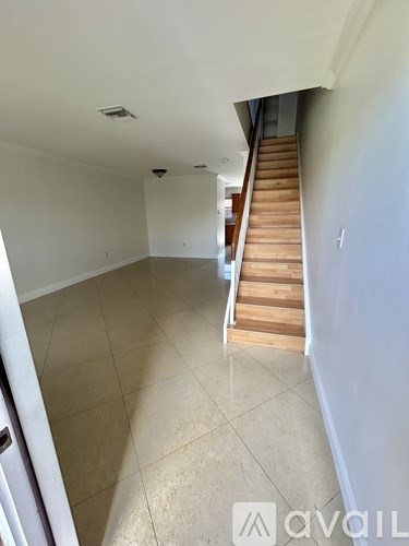 A room with a staircase and a tiled floor.