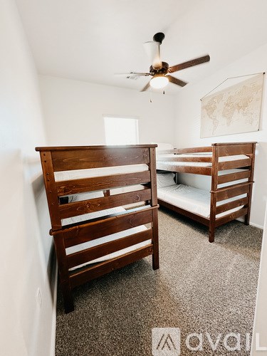 A room with two bunk beds and a ceiling fan.