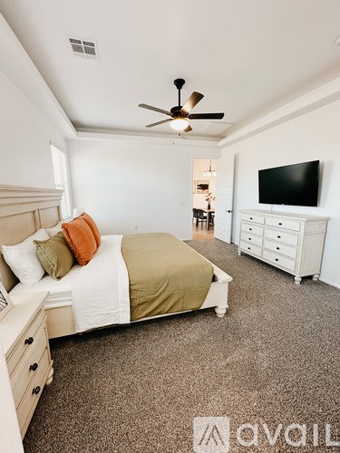 A bedroom with a bed, dresser, and television.