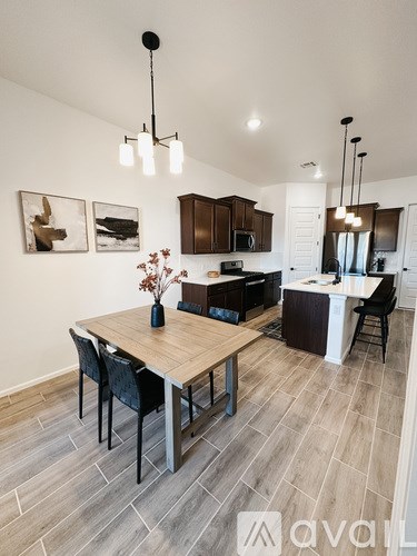 A modern kitchen with a wooden dining table and chairs.