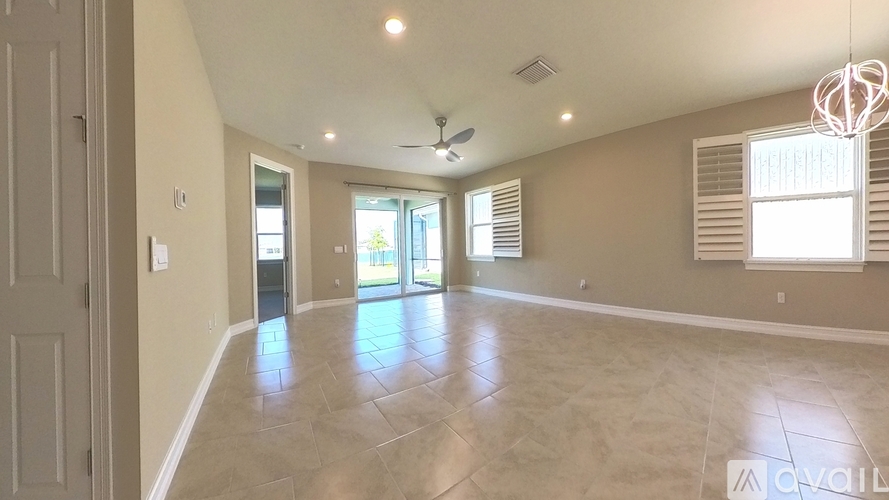 A spacious room with a tiled floor and a ceiling fan.