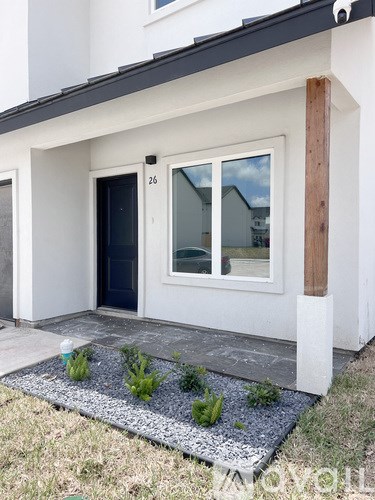 A white house with a black door and a window with a view of the sky.