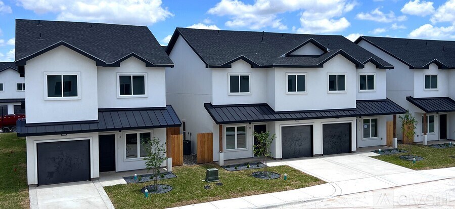A row of modern houses with black roofs and white walls.
