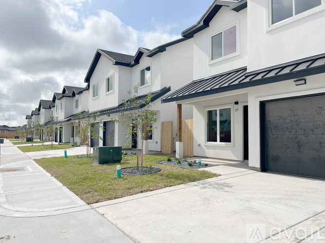 A row of white houses with black roofs and a clear sky.