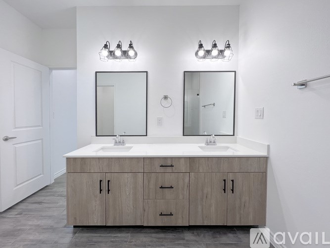 A bathroom with a vanity and two mirrors.