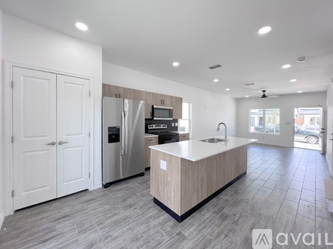A modern kitchen with a central island and a refrigerator.
