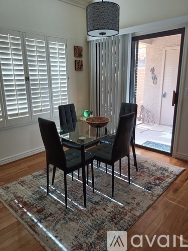 A dining room with a table and four chairs.