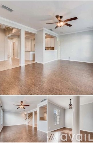 A living room with a ceiling fan and a kitchen area in the background.