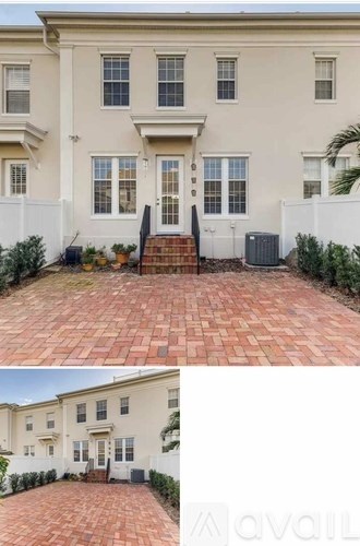 A two-story house with a brick walkway leading to the front door.