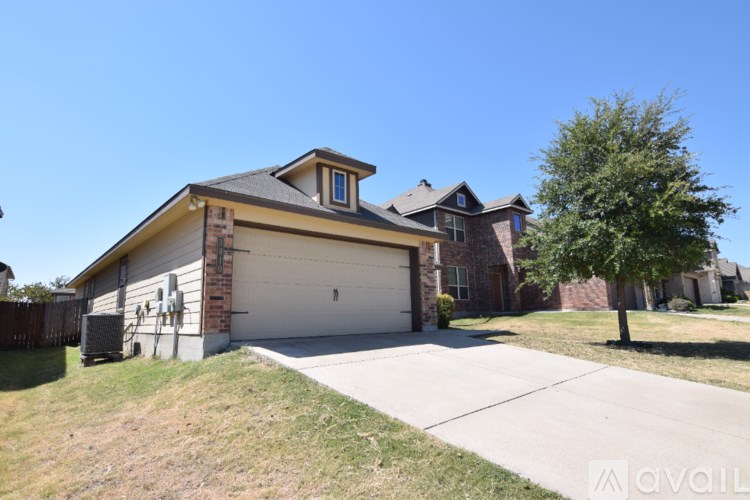 A two-car garage is attached to a brick house.