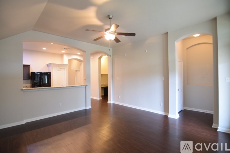 A room with a carpeted floor and a ceiling fan.