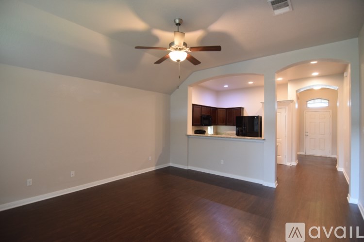 A room with a ceiling fan and carpeted floor.