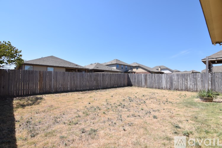 A white door is open to a room with a concrete floor.