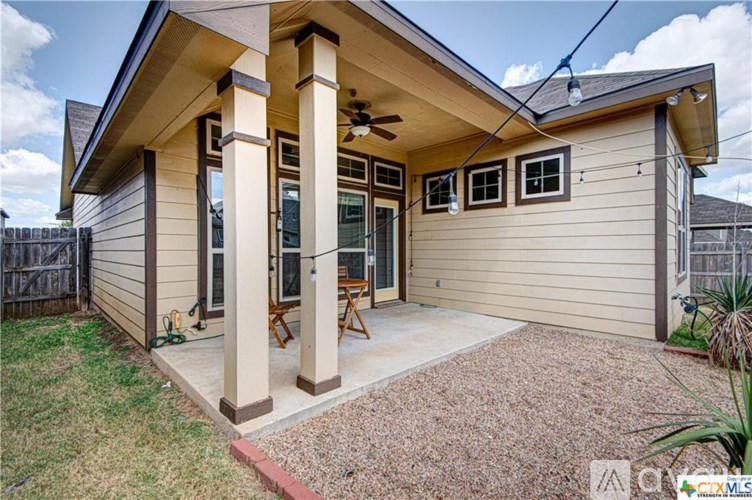 A house with a covered patio and a ceiling fan.