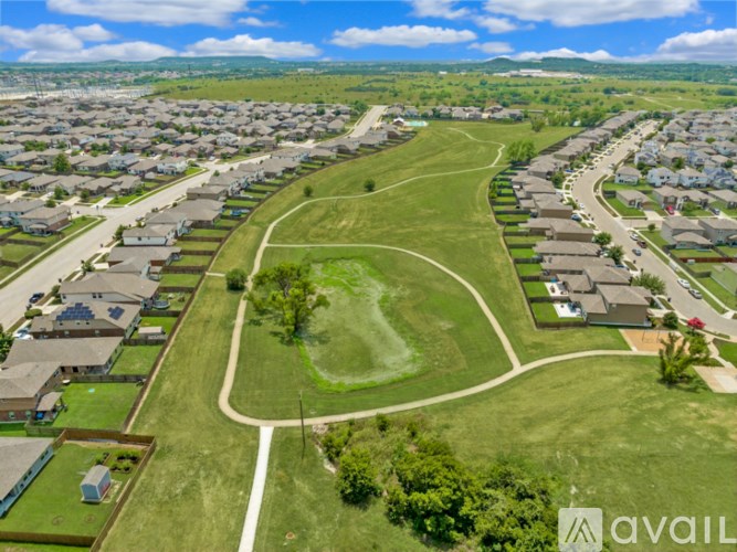A bird's eye view of a residential area with houses and a green park.
