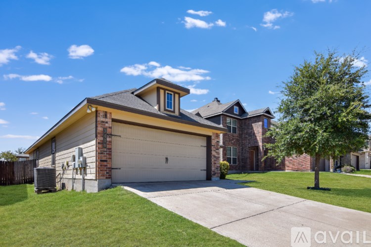 A house with a garage and a tree in front.