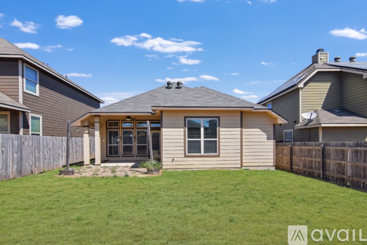 A house with a brown roof and a fence in front of it.