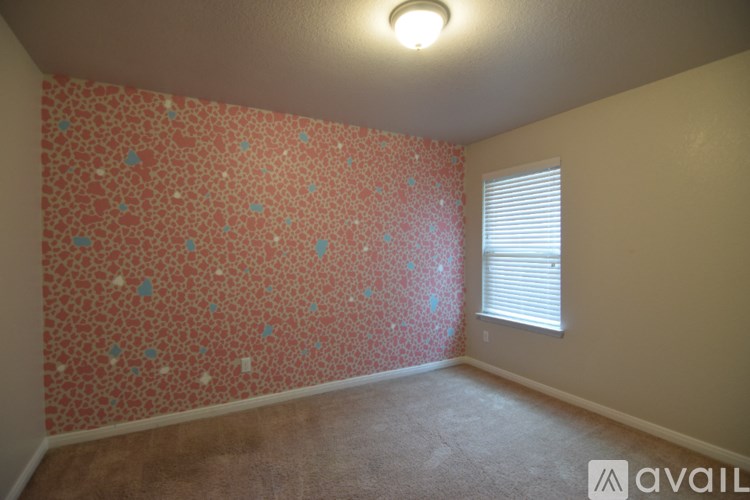 A room with a chandelier and a view of a street through a window.