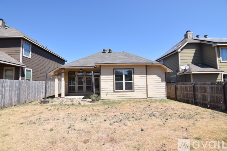 A kitchen with dark wood cabinets and a black refrigerator.