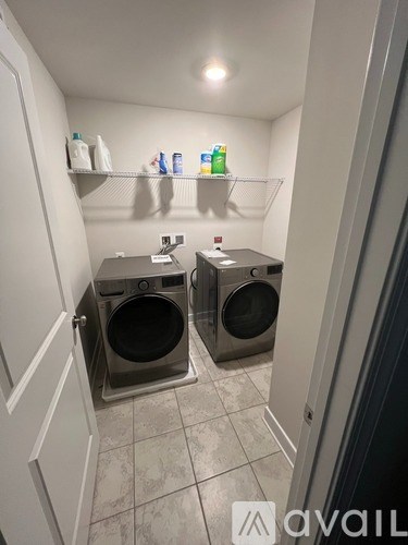 A laundry room with two washing machines and shelves with cleaning supplies.