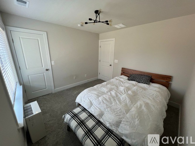 A bedroom with a bed, a ceiling fan, and two doors.