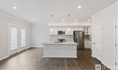 A modern kitchen with white cabinets and a center island.
