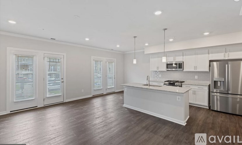 A modern kitchen with stainless steel appliances and white cabinetry.