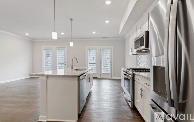 A modern kitchen with stainless steel appliances and wooden floors.