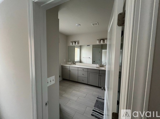 A bathroom with a sink, mirror, and cabinets.