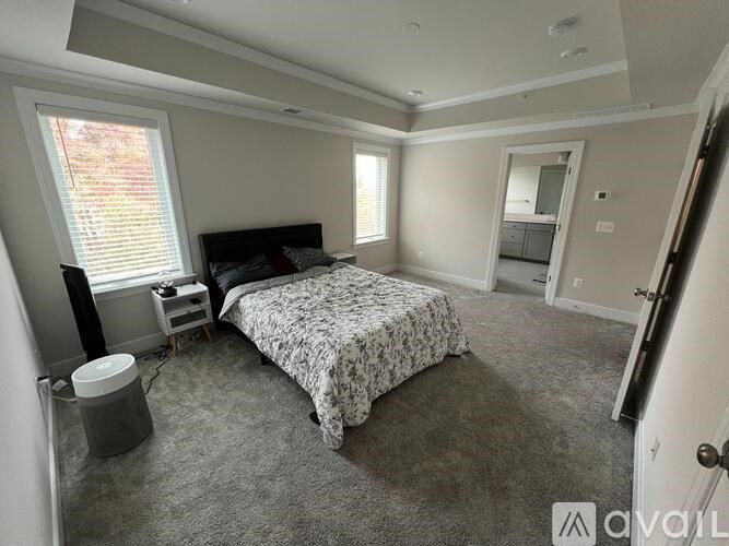 A bedroom with a bed, dresser, and window.