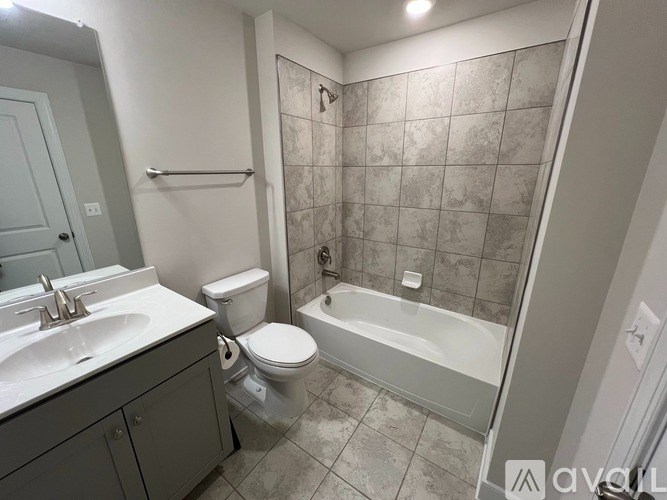 A bathroom with a toilet, sink, and bathtub.