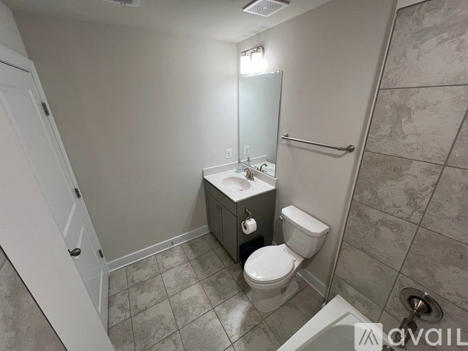 A bathroom with a toilet, sink, and mirror.