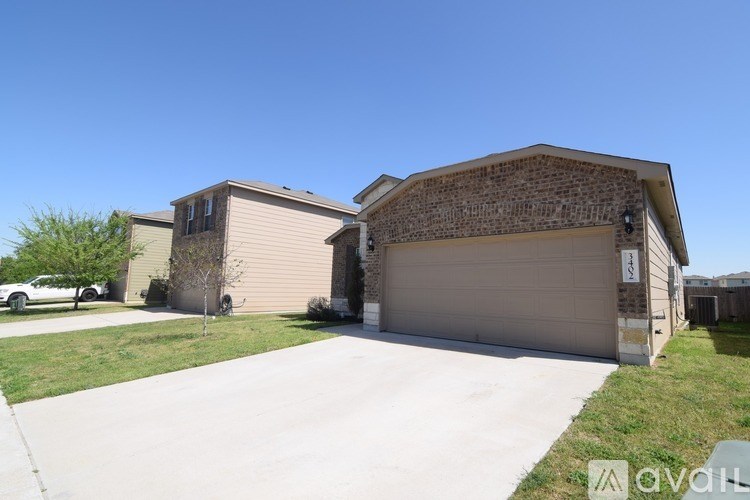A house with a garage and a driveway in front of it.