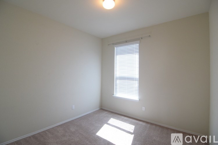 A room with a window and a carpet on the floor.