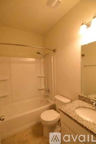 A bathroom with a toilet, sink, and bathtub.