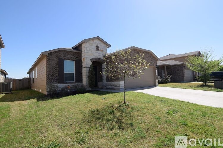 A house with a front yard and a tree in bloom.