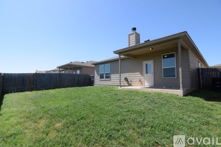 A house with a fence and a green lawn.