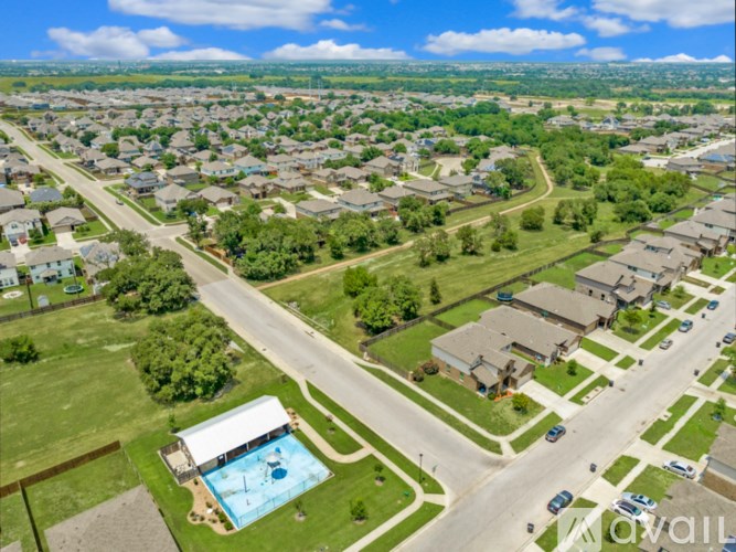 A suburban neighborhood with a swimming pool and a road running through it.