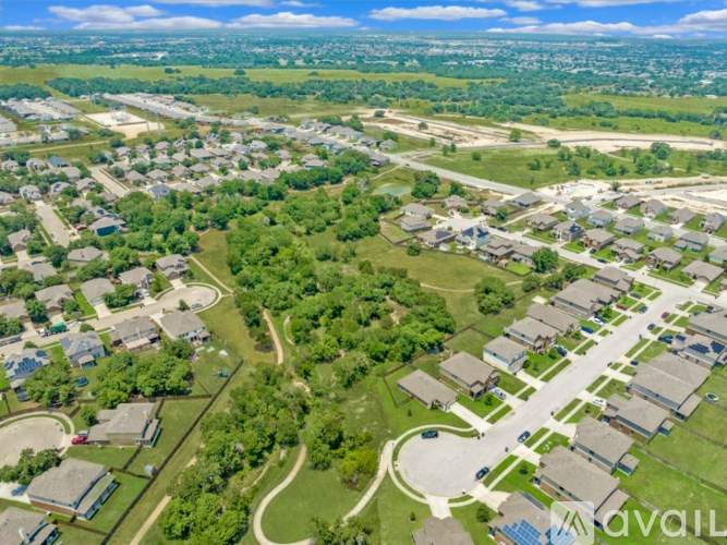 A bird's eye view of a residential area with houses and greenery.