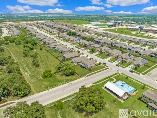 A bird's eye view of a residential area with houses, roads, and a swimming pool.