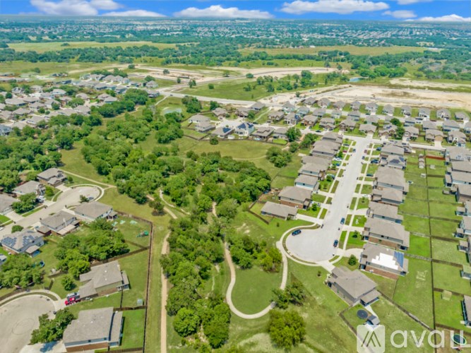 A bird's eye view of a residential area with houses and greenery.